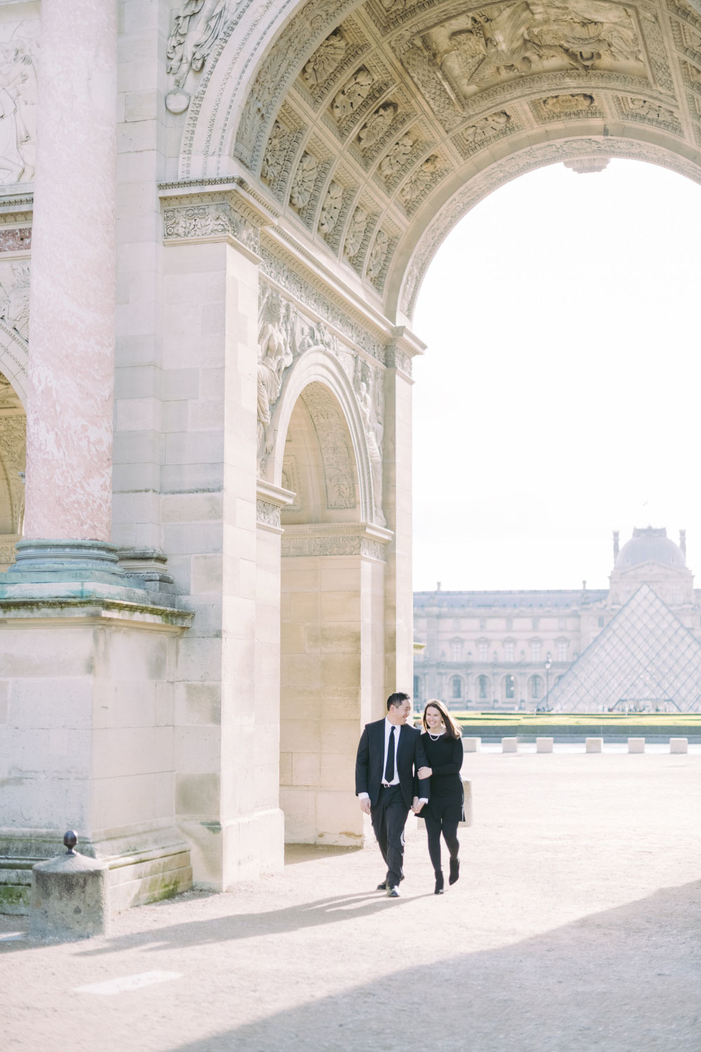  lovers are walking at the louvre museum in paris.